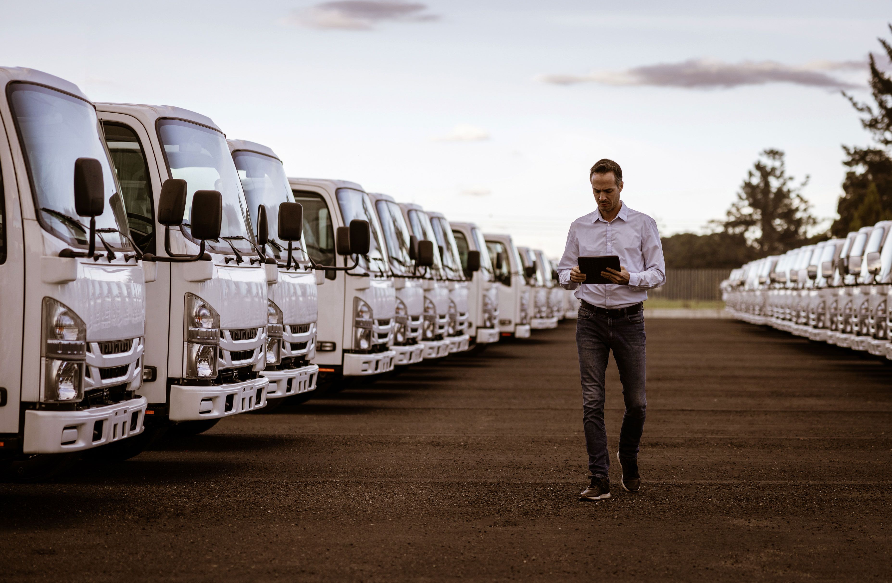 man with clipboard between trucks