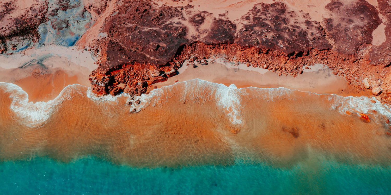 overhead view of water hitting rocks with vibrant colours