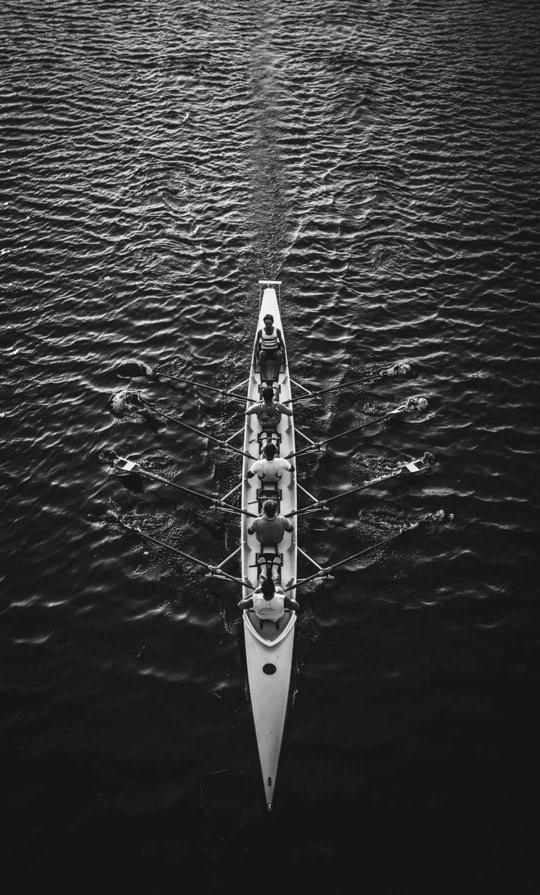 Row boat with five people in black and white