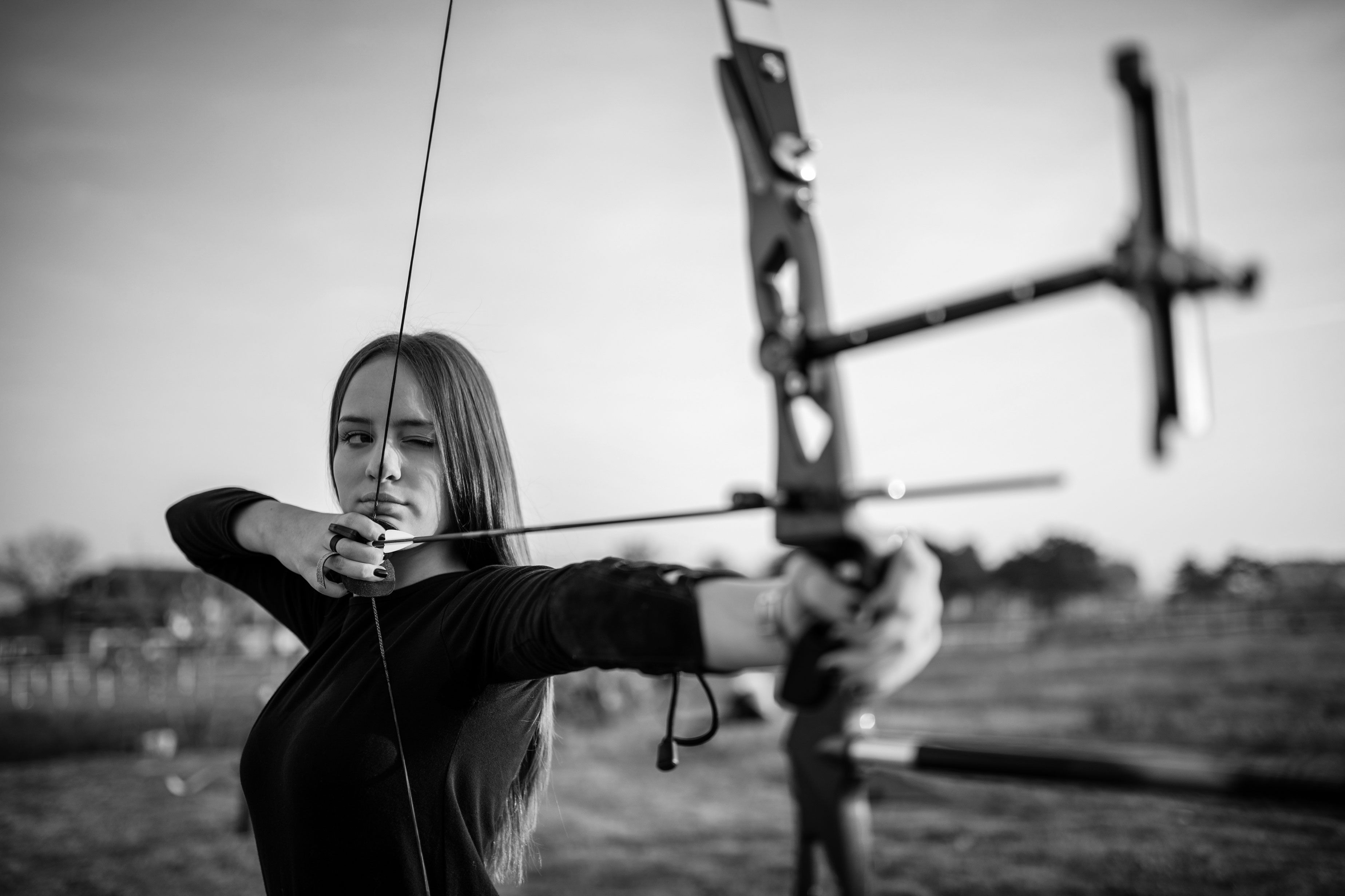 Lady holding bow and arrow aiming at target