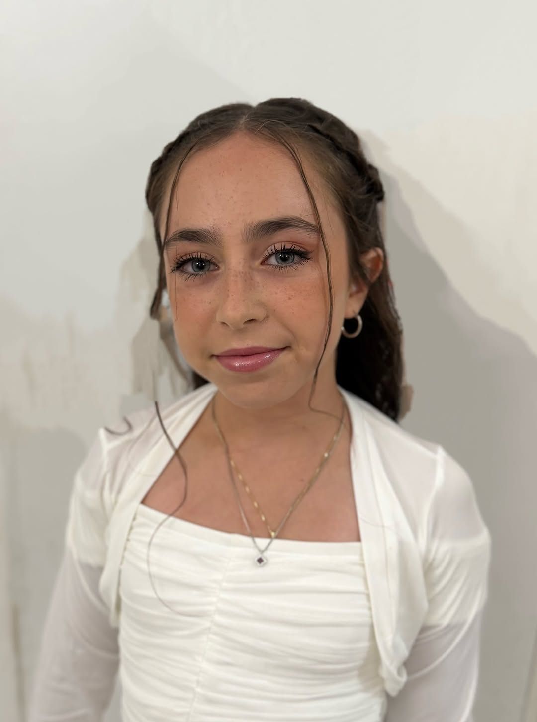 איפור עדין עם שפתיים מבריקות, תסרוקת קלועה עם פוני פזור