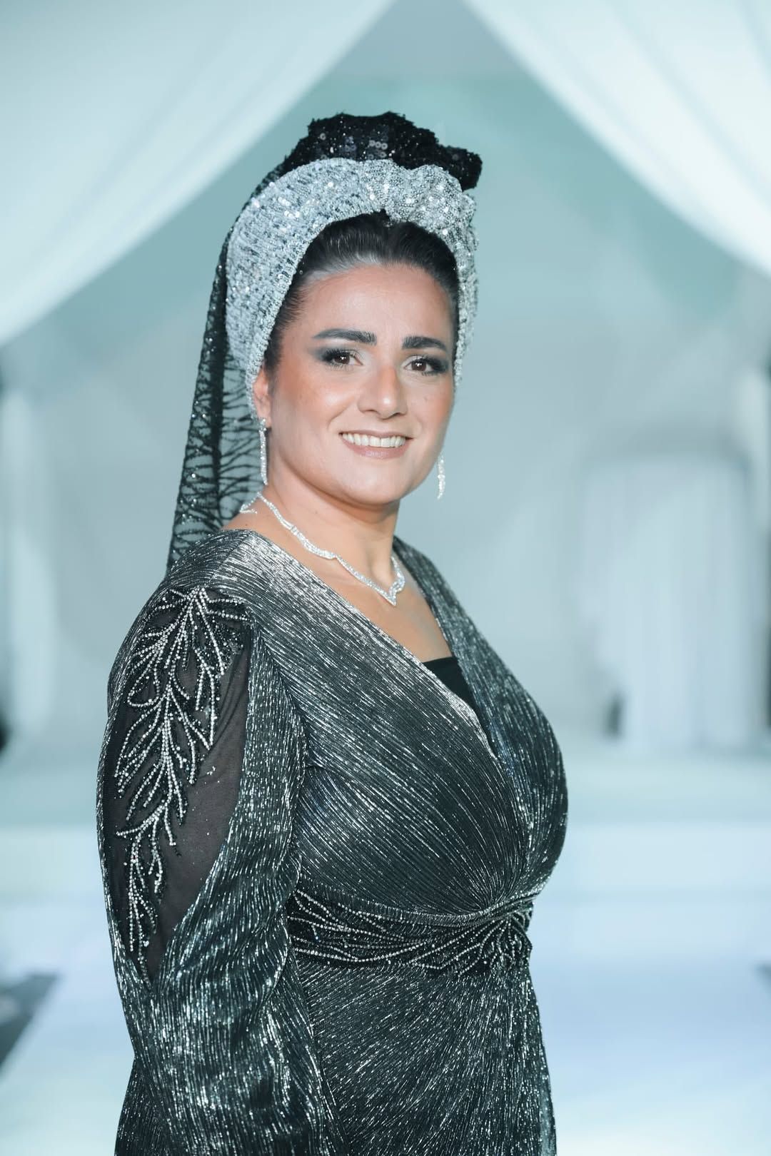 איפור עיניים מודגש עם גבות מעוצבות; מטפחת ססגונית עם קשירה דקורטיבית