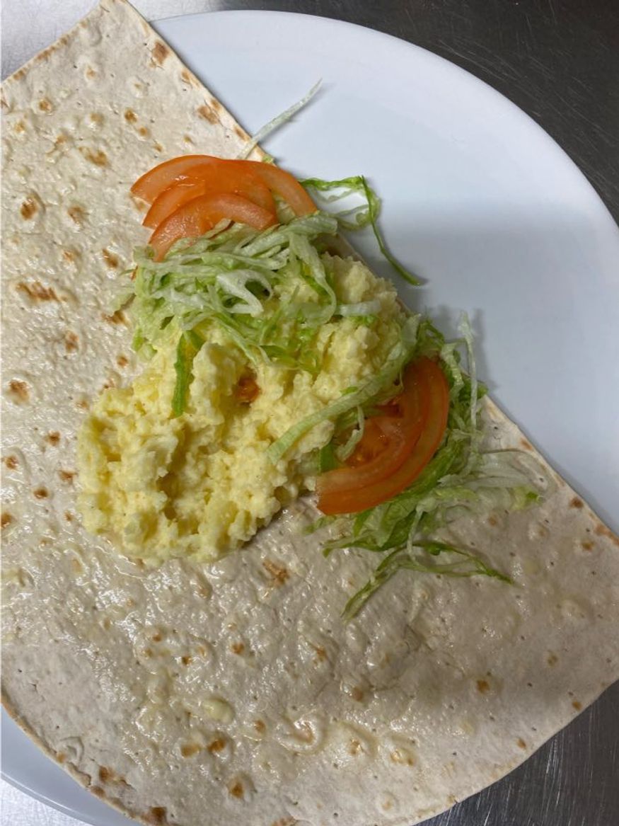 Första lagret ingredienser placeras på brödet