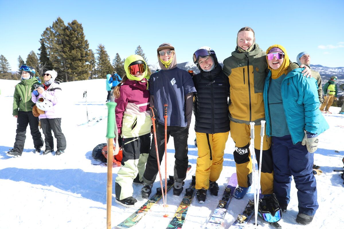 Group of skiers and snowboarders smiling together on the snow