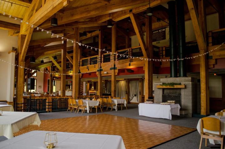 Lodge event space with exposed timber beams, dining tables, and dance floor