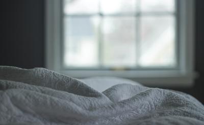 Bed by a window in soft morning light