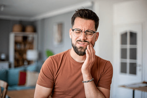 Man holding his jaw because of a toothache