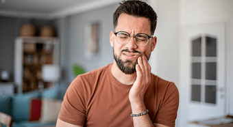 Man holding his jaw because of a toothache