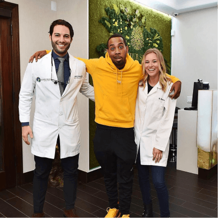 Television personality JoJo Simmons posing with the team at Bensonhurst Dental Care