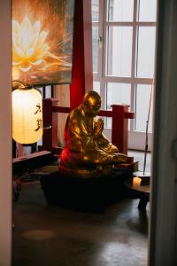 Figur: Betender Buddha in Gold