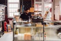 Mitarbeiter steht hinter der Theke in der Pizzeria
