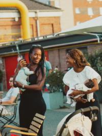 Zwei Frauen mit Babies auf dem Arm