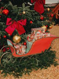 Schlitten vor dem Weihnachtsbaum mit Geschenken
