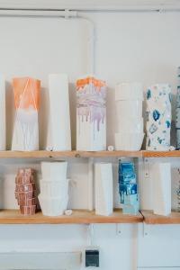 Mehrere handgemachte Porzellanvasen auf einem Regal