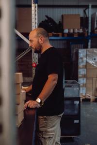 Mitarbeiter steht an der Paketabfertigung und arbeitet am Computer