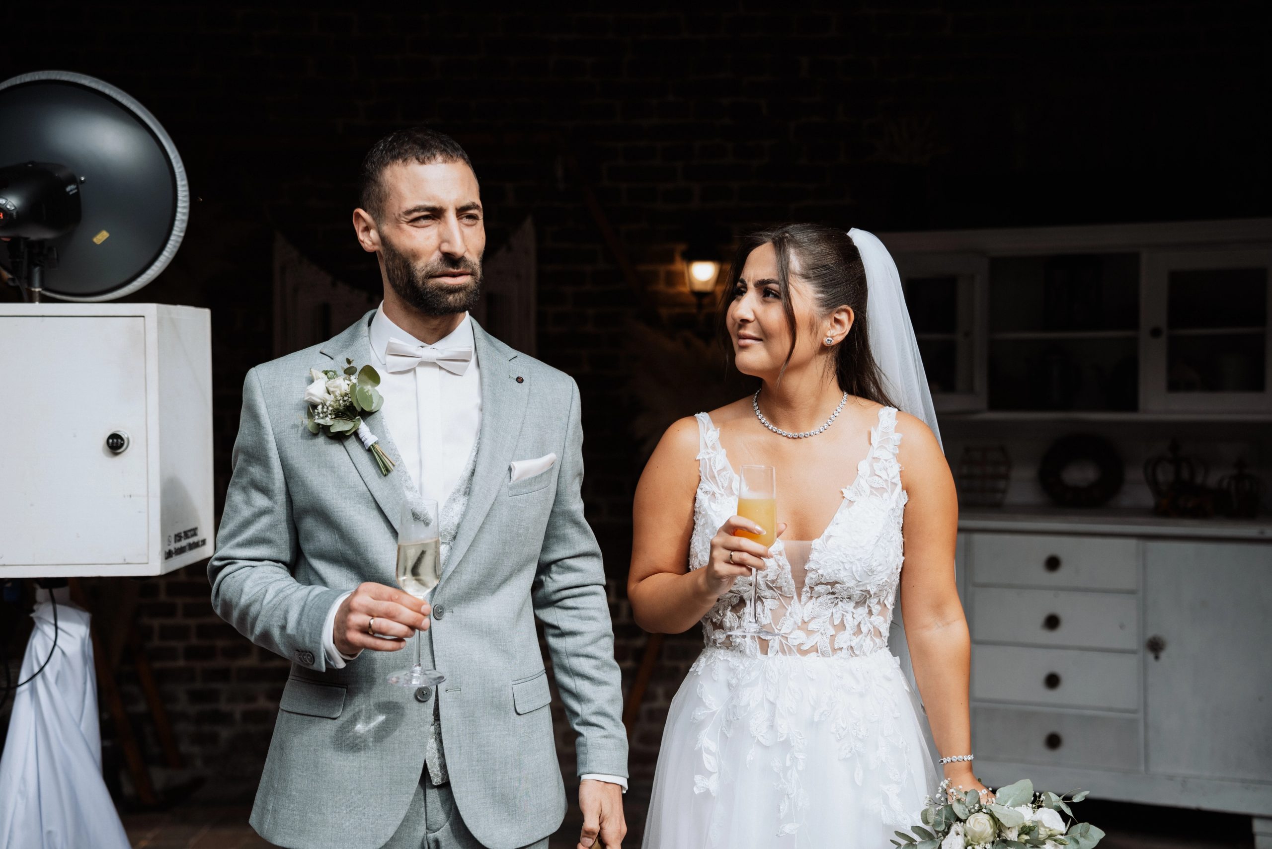 Merve und Timur mit Sektgläsern im Innenhof