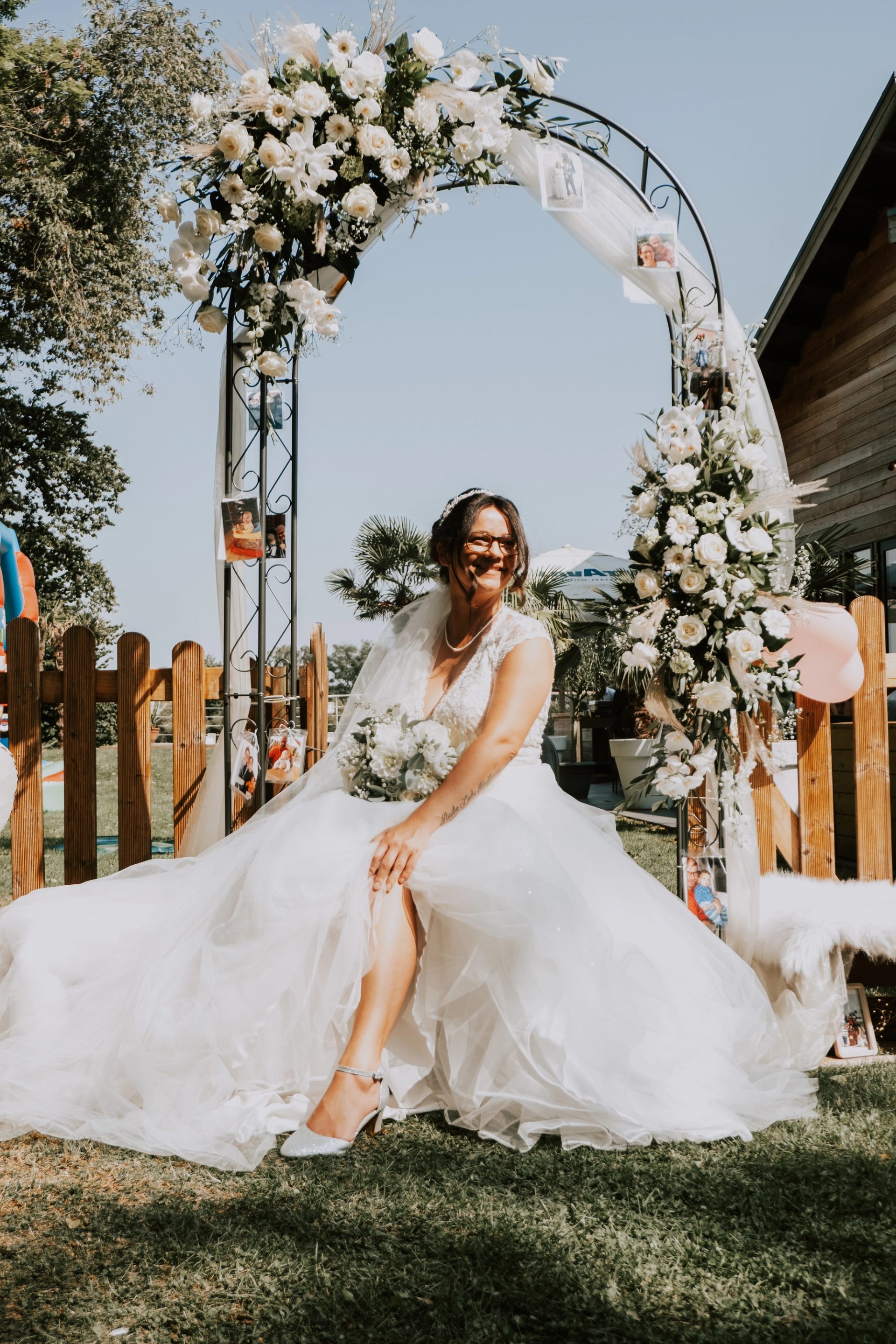 Rebecca sitzt unter dem Blumenbogen im Garten des Aloha Beach House