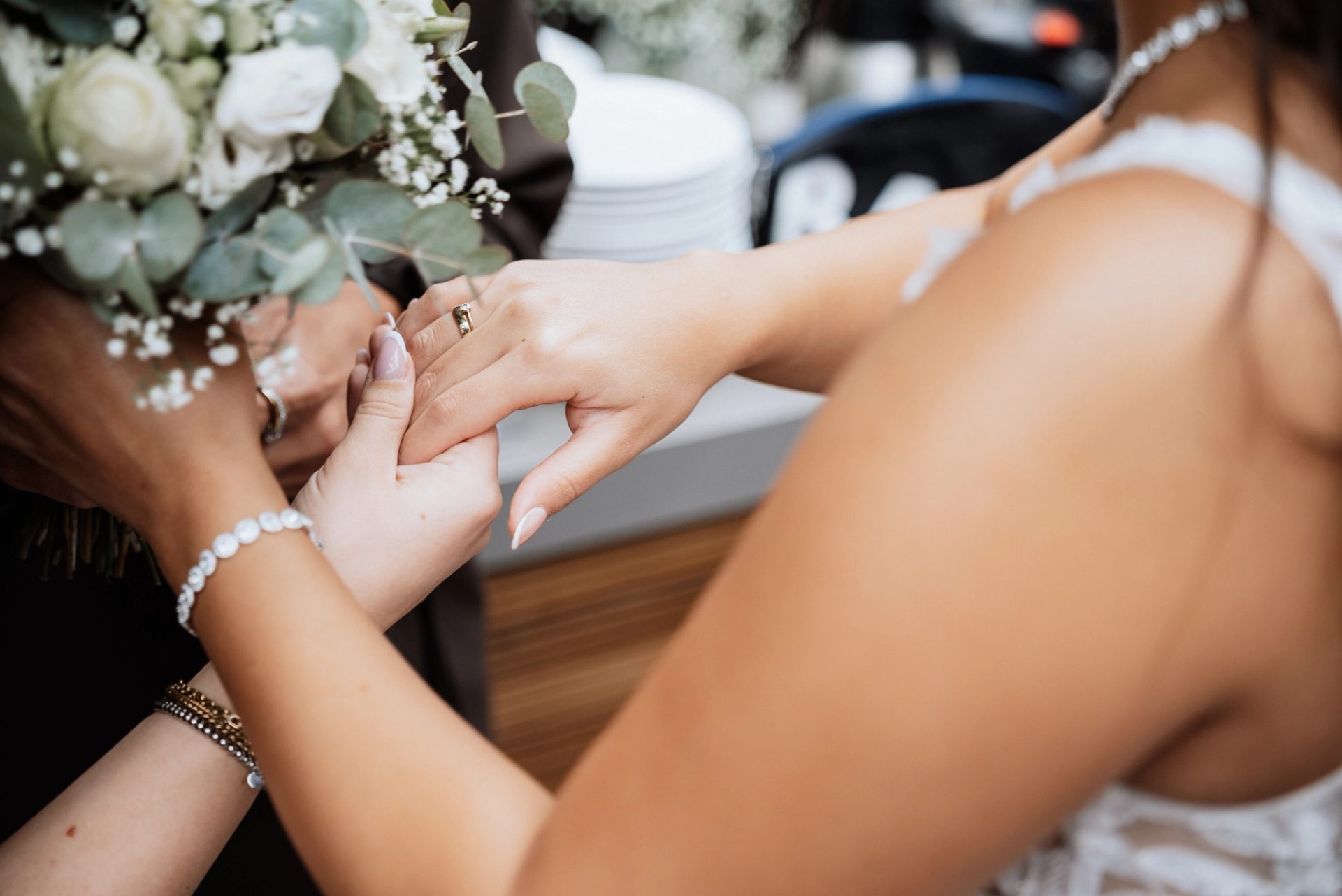 Eine Freundin hält Merves Hand und sieht sich den Ring an