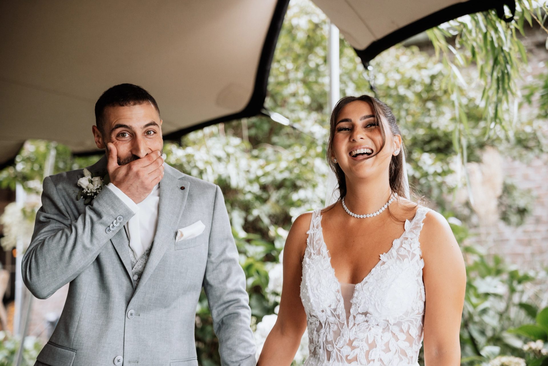 Timur hält sich lachend die Hand vor den Mund, Merve lacht mit