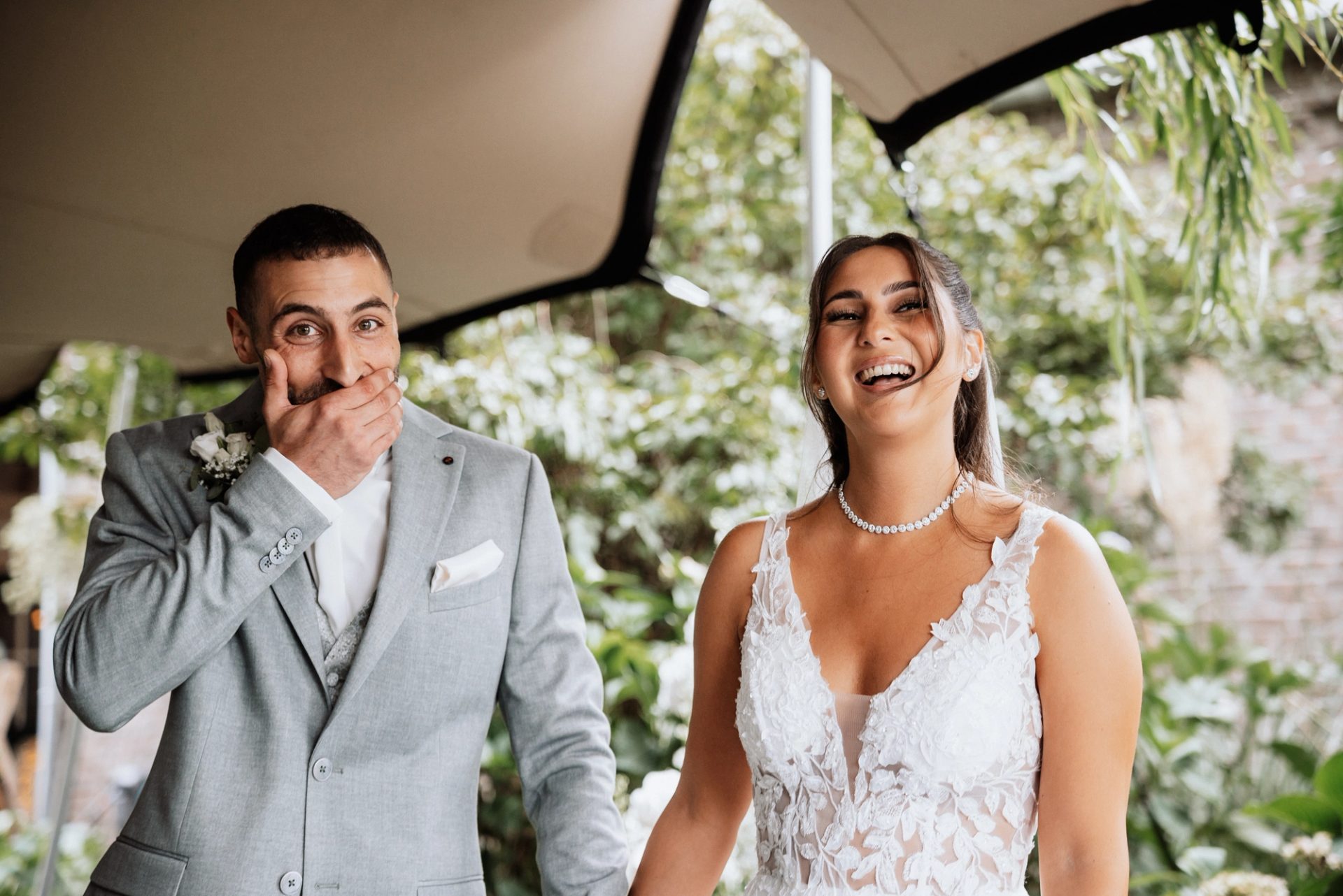 Timur hält sich lachend die Hand vor den Mund, Merve lacht mit