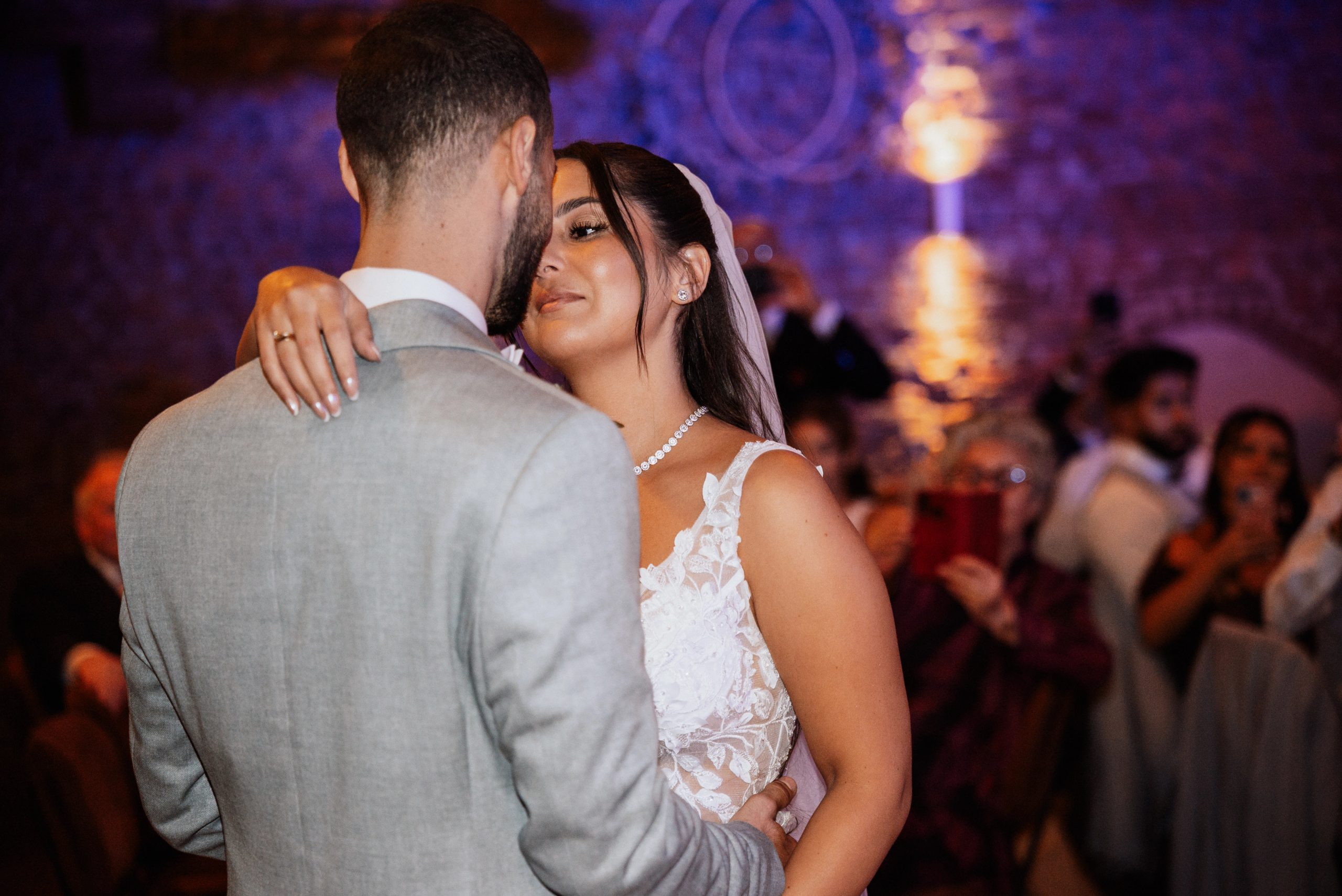 Merve und Timur tanzen eng im violetten Licht des Saals