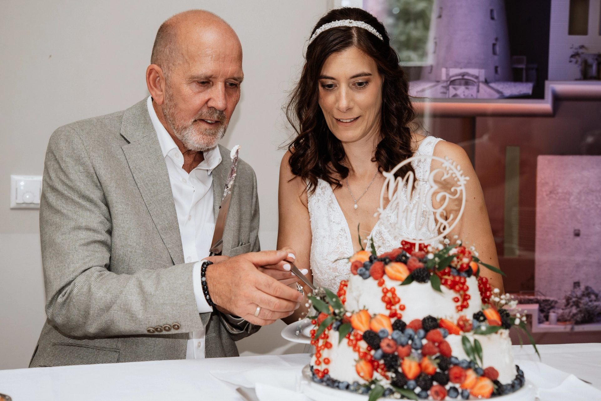 Ralph setzt das Messer an die Torte, Maren sieht zu