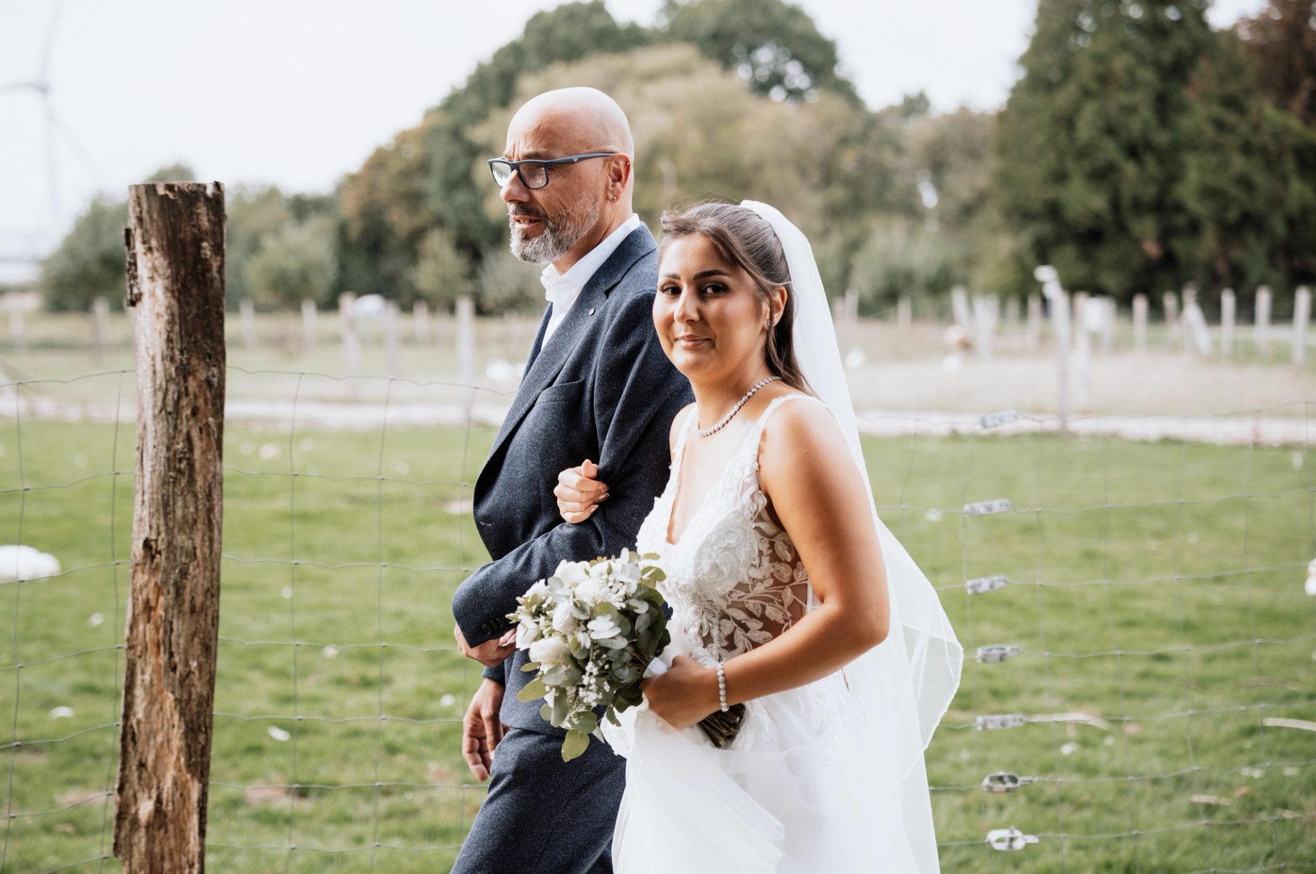 Merve und ihr Vater auf dem Weg zur Trauung, sie hält ihren Brautstrauß