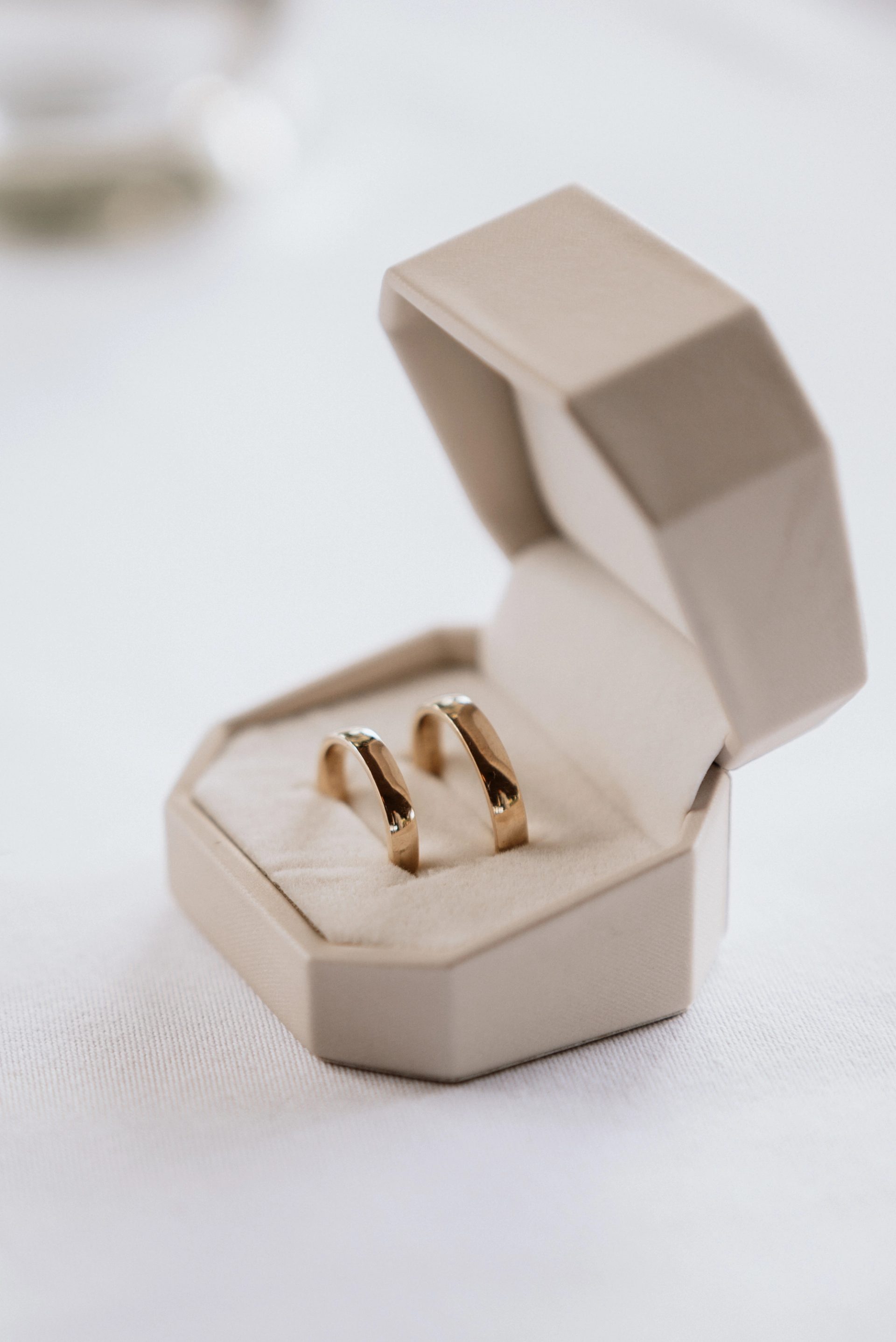 Die beiden goldenen Eheringe in einer hellen Schachtel