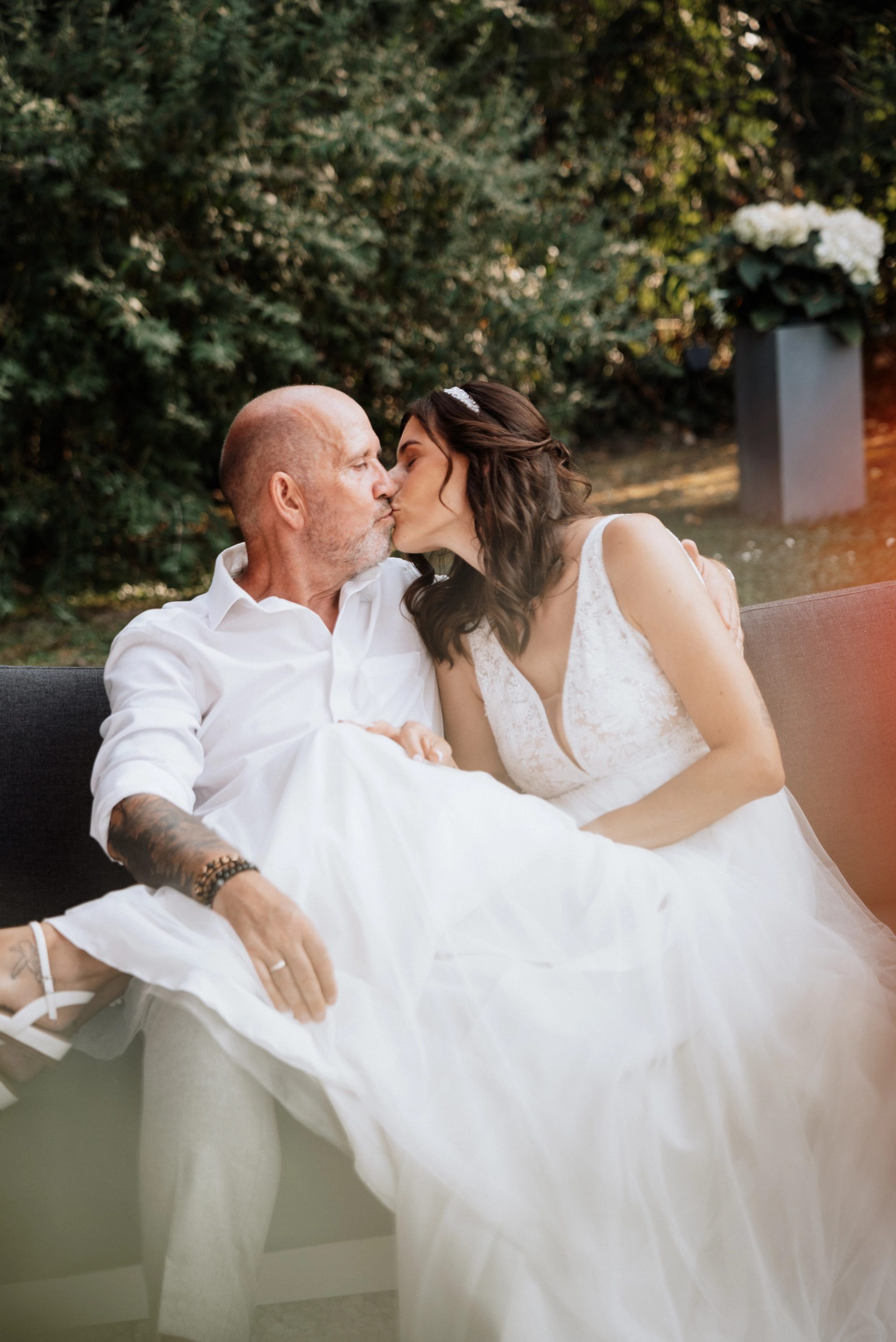 Ralph und Maren küssen sich auf dem Gartensofa