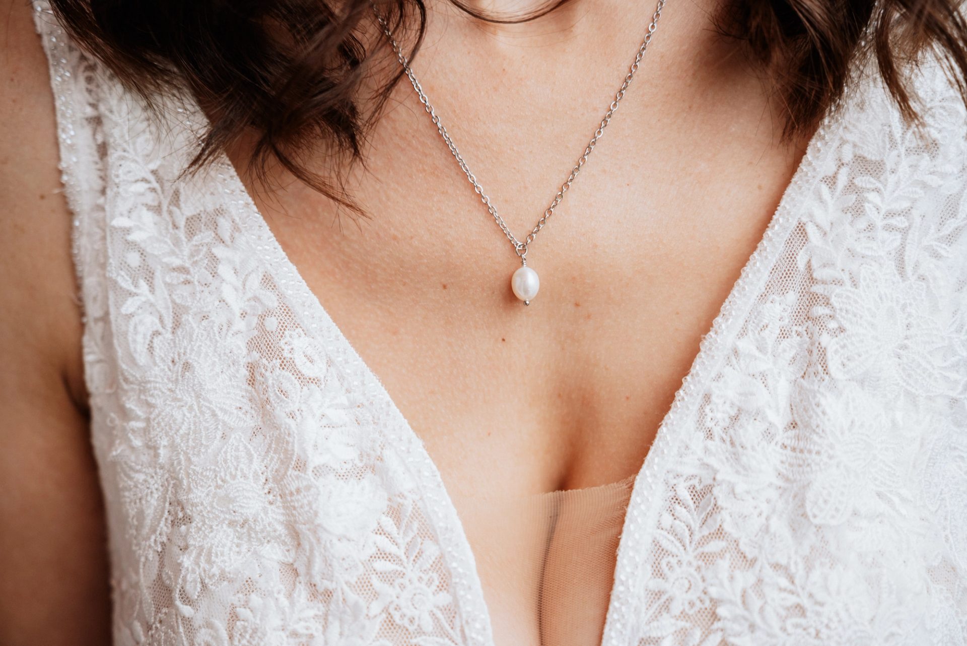 Nahaufnahme: Perlenkette auf der Spitze von Marens Brautkleid