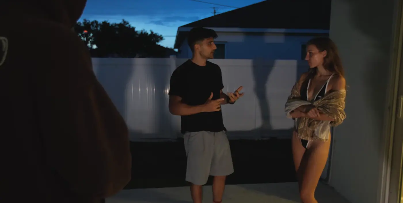 Ben talking to Anya Lacey outside her house in Florida at dusk