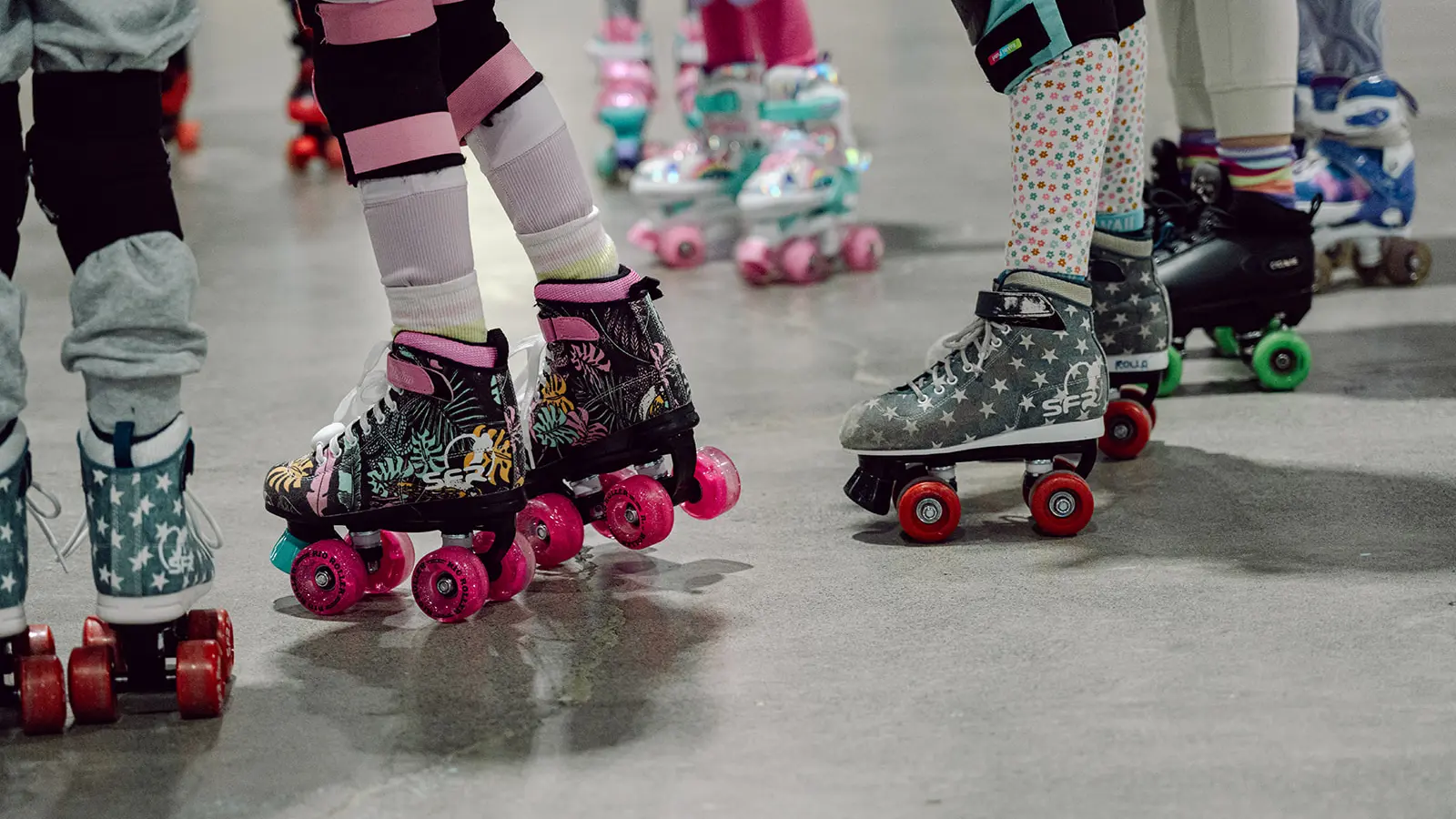 Close up of brightly coloured and patterned roller skates on kids feet at Rolla Skate Club in Vancouver.