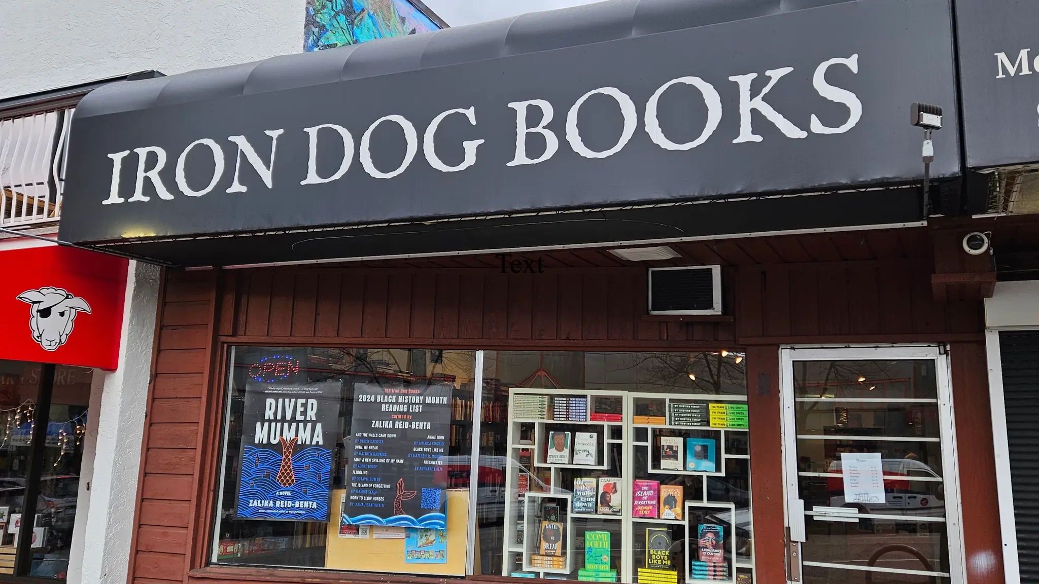 The exterior of Iron Dog Books in Vancouver. There are books and book posters in the window.