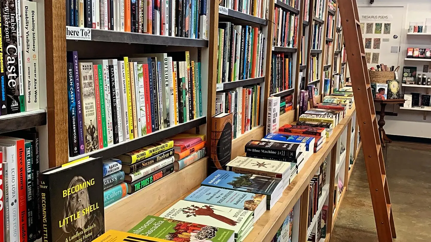 The interior of Upstart and Crow book store in Vancouver. Bookshelves cover a wall with a ladder leaning against it.