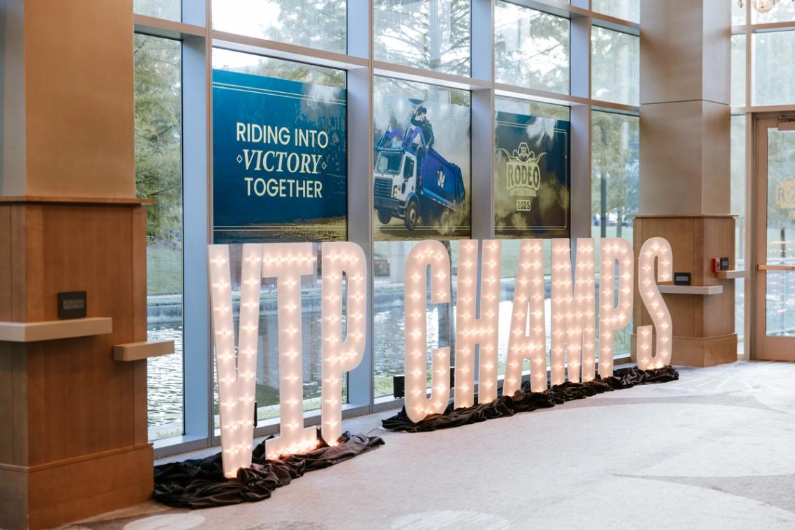 VIP CHAMPS marquee letters beneath the Riding into Victory Together window graphics
