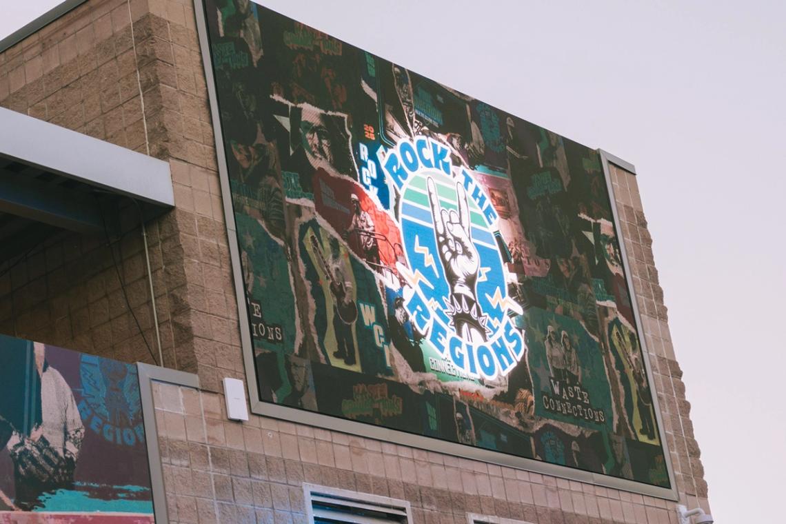 Rock the Regions collage mural mounted high on the venue's brick interior wall