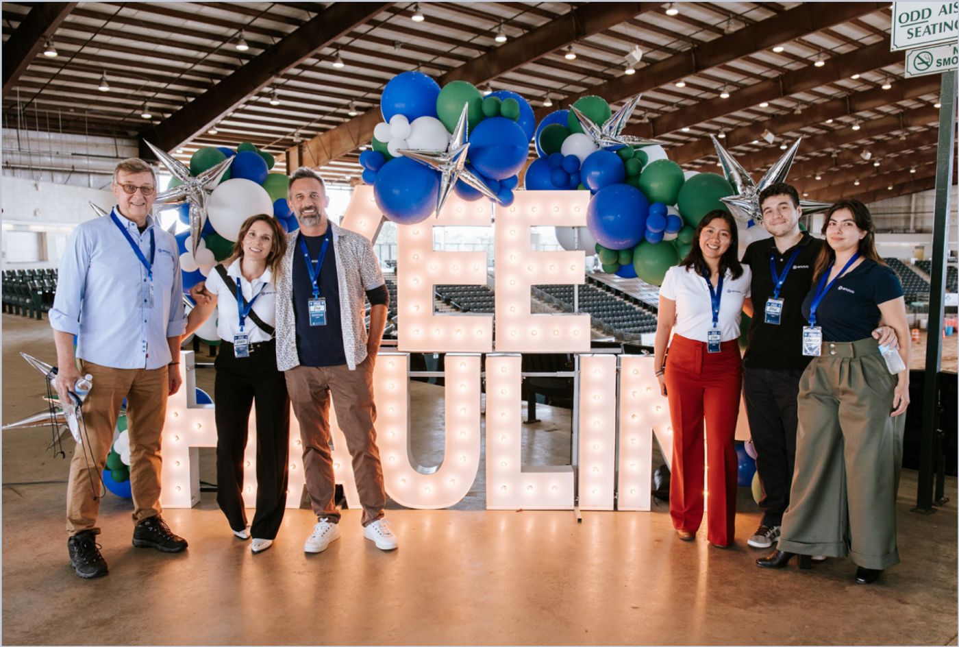 Enova team in front of the illuminated marquee letters at the event