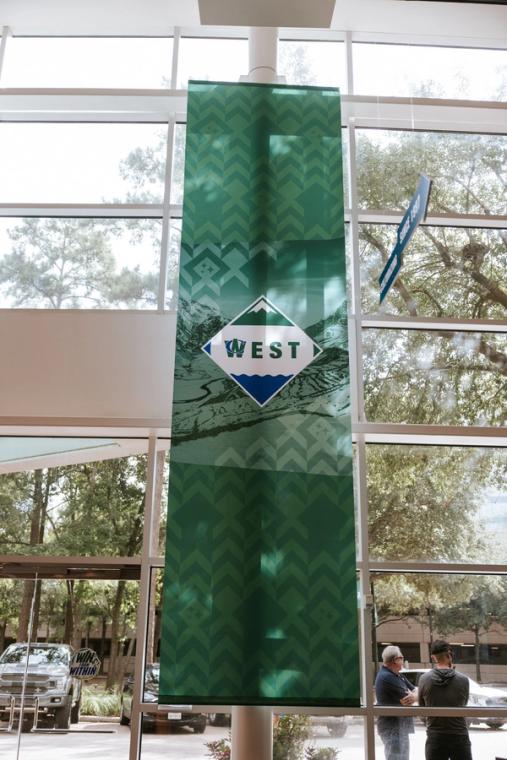 Green West region banner hanging in the glass atrium