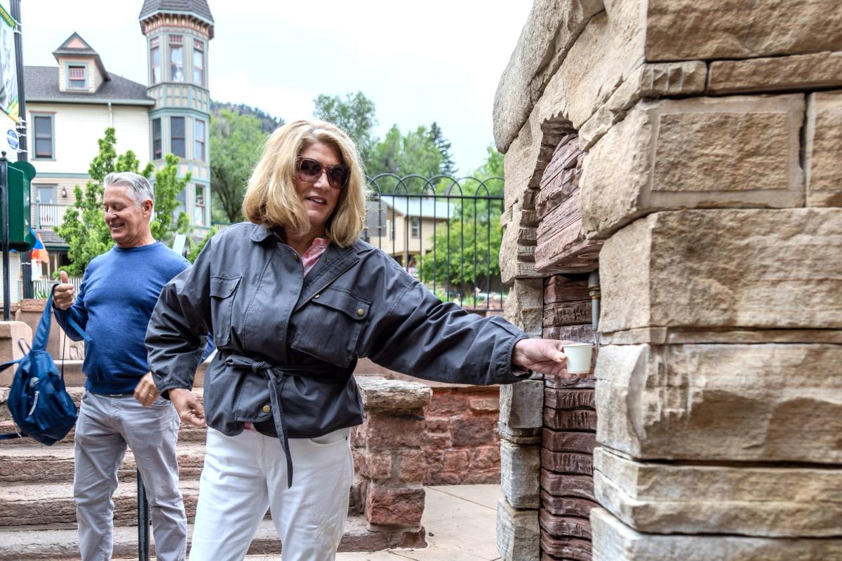 Woman drinking from mineral spring on Manitou Spring Food tour with Rocky Mountain Food Tours