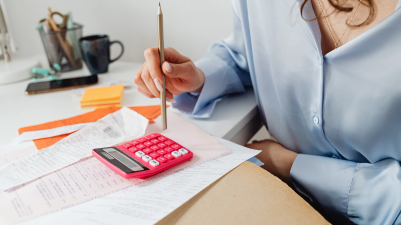 Reviewing business power bills with calculator and receipts on desk.