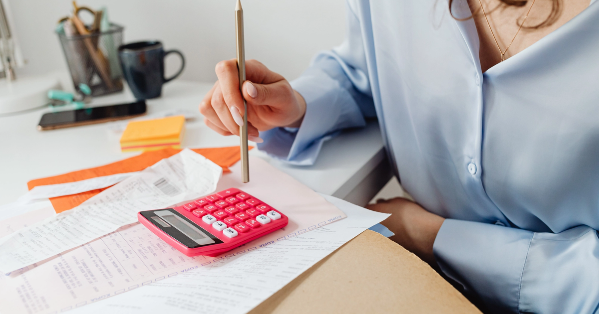 Reviewing business power bills with calculator and receipts on desk.