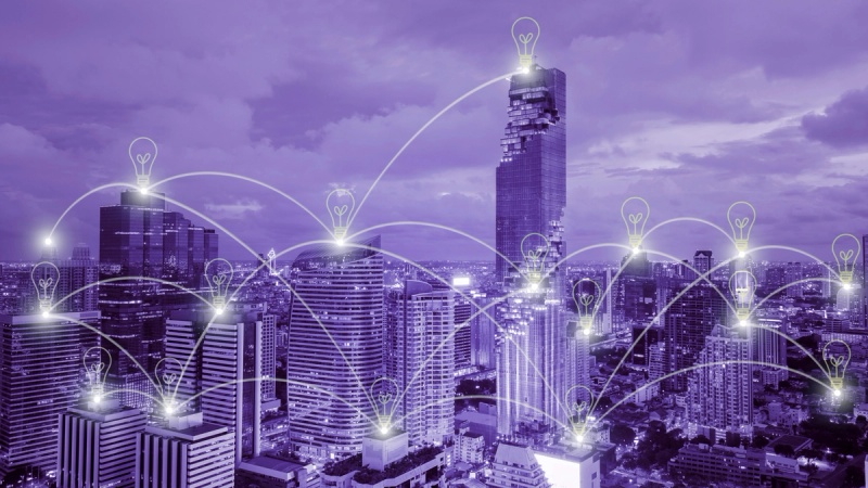 A digital illustration of a cityscape at night with glowing light bulb, emphasizing how to cut costs with energy-saving tips.