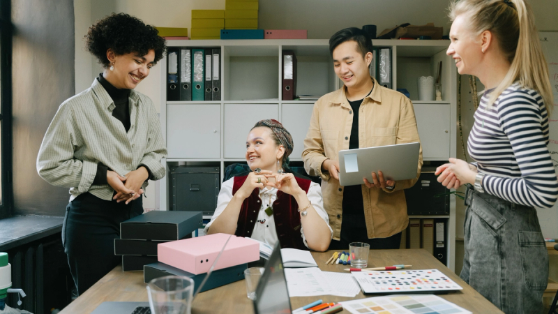 A diverse group of people smiling and collaborating. 