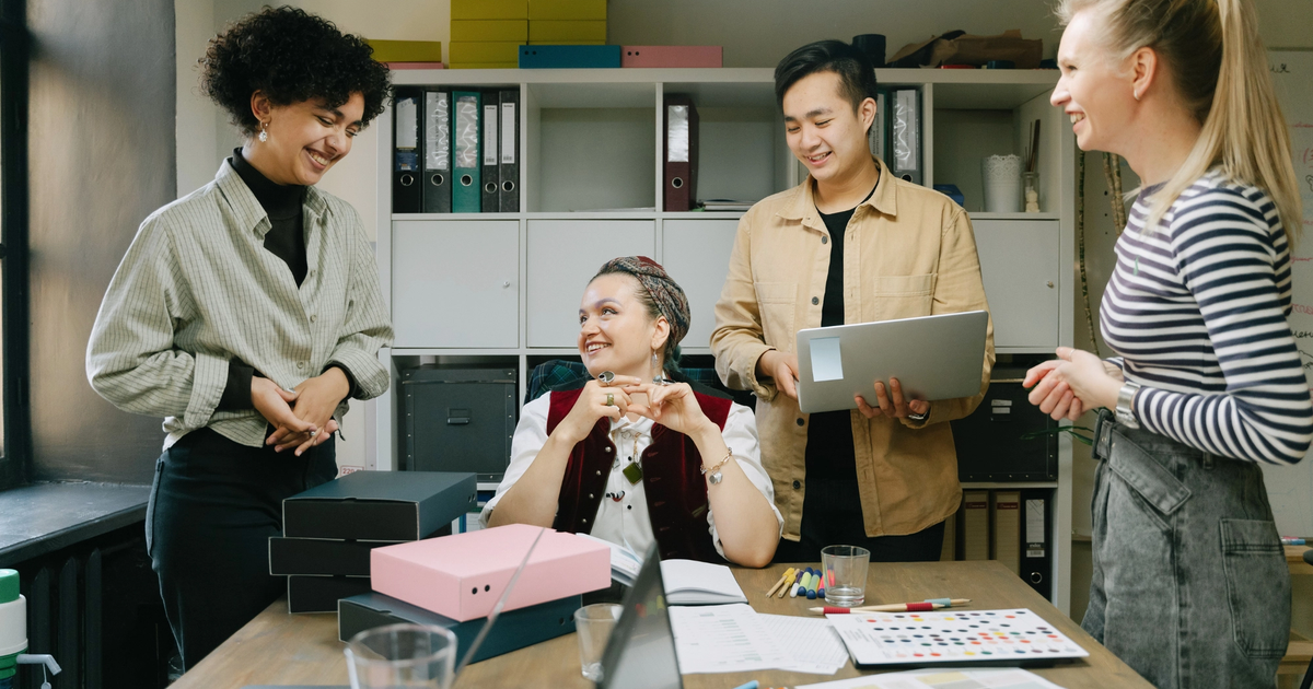 A diverse group of people smiling and collaborating. 