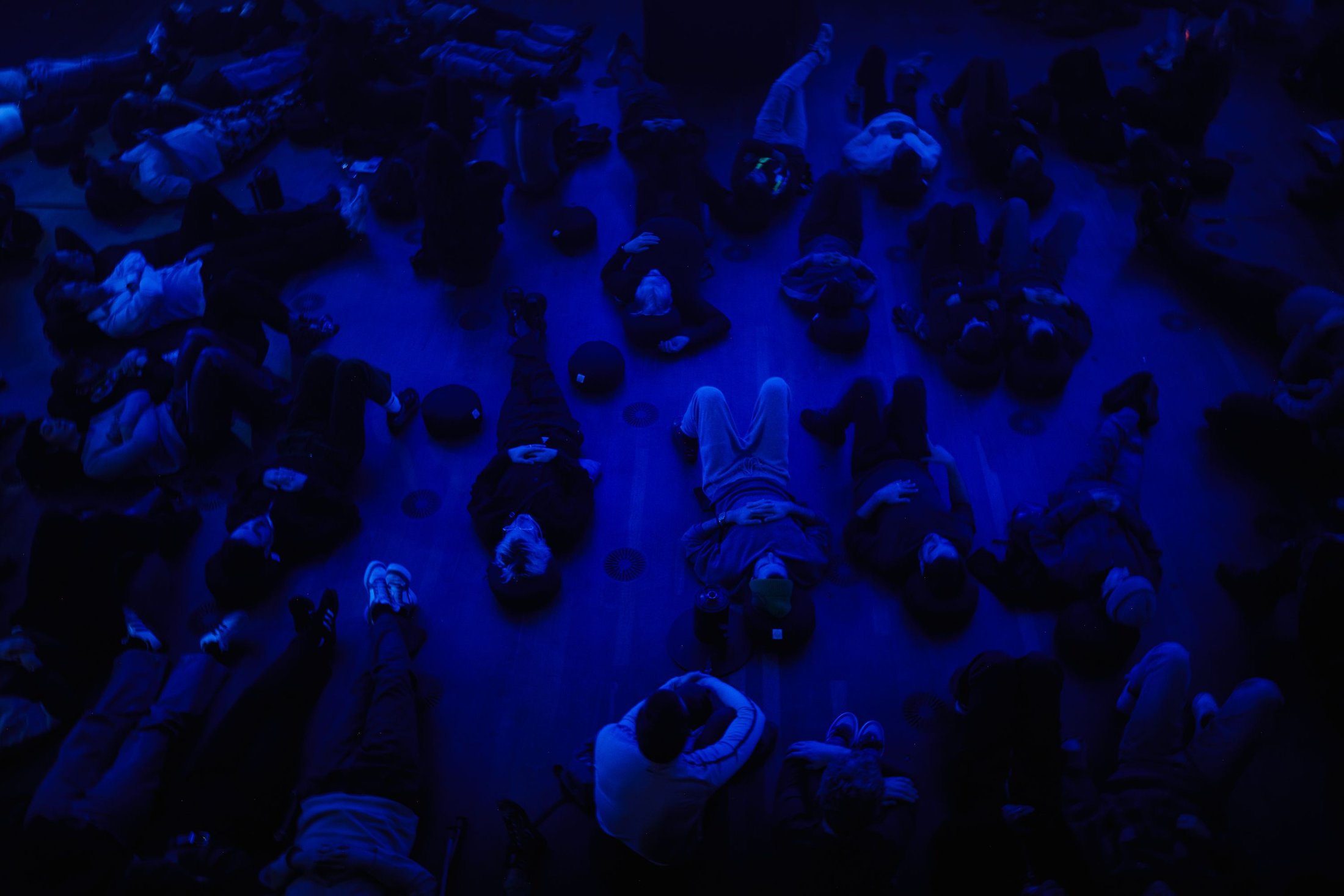 A group of people listening together in a dimly lit room. 