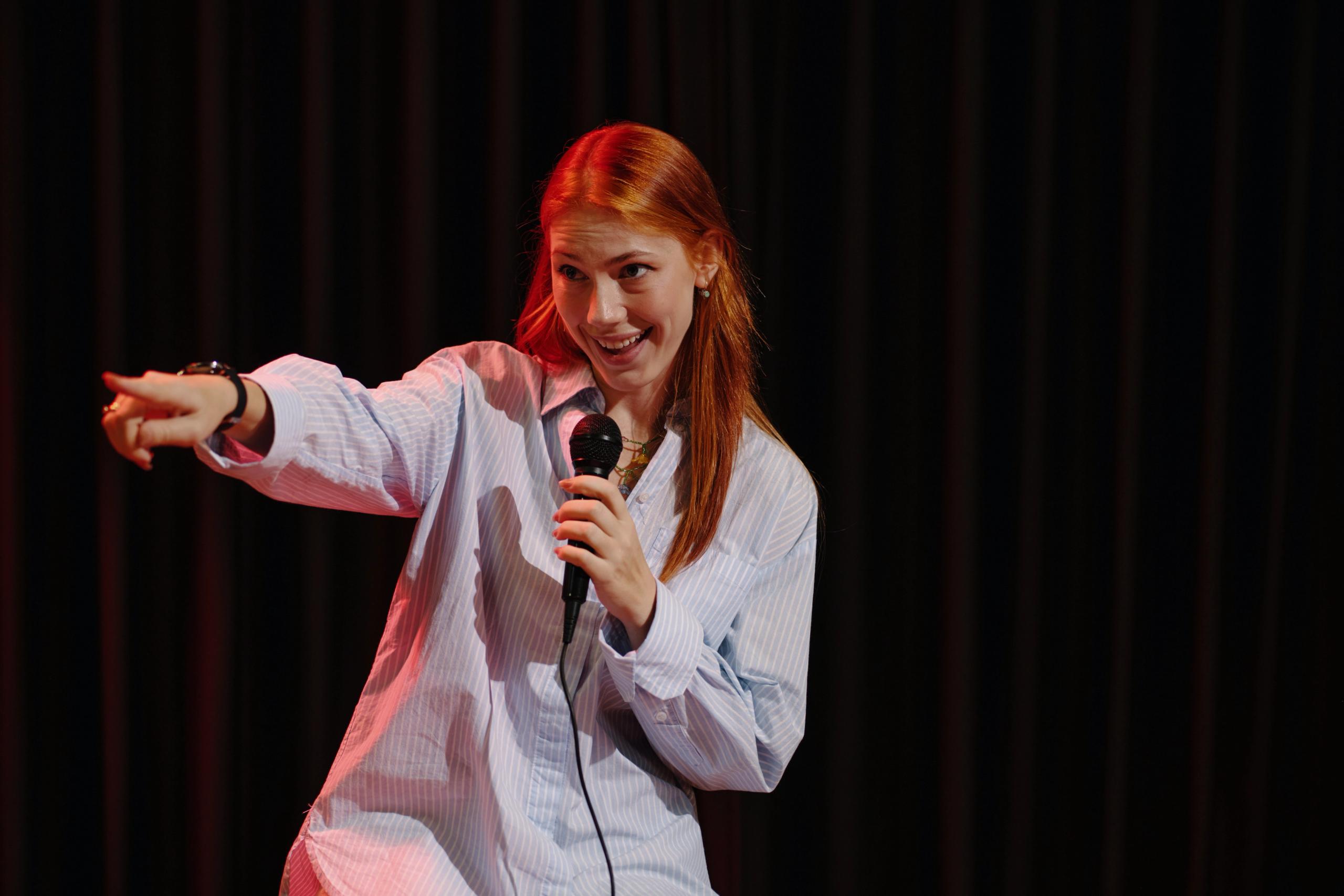 Kobieta występująca na scenie stand-up z mikrofonem.