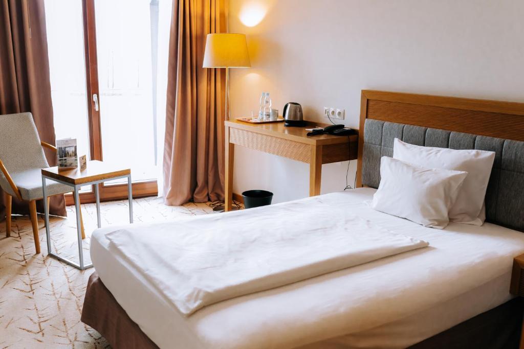 Pokój hotelowy z jednym łóżkiem i widokiem na okno.