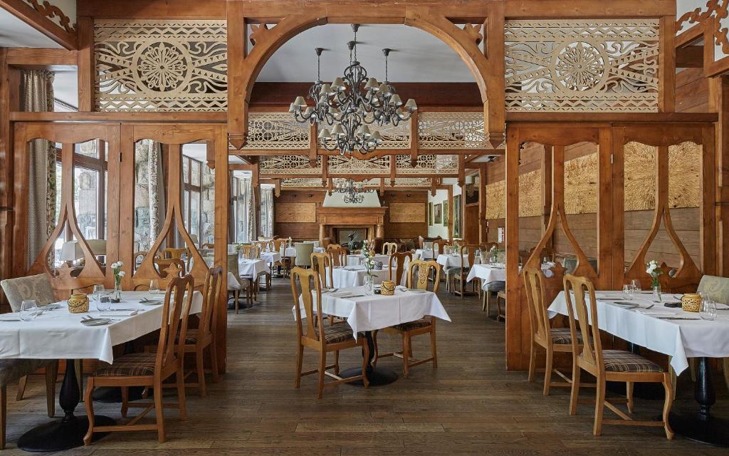 Sala restauracyjna z klasycznymi zdobieniami i drewnianymi ścianami.