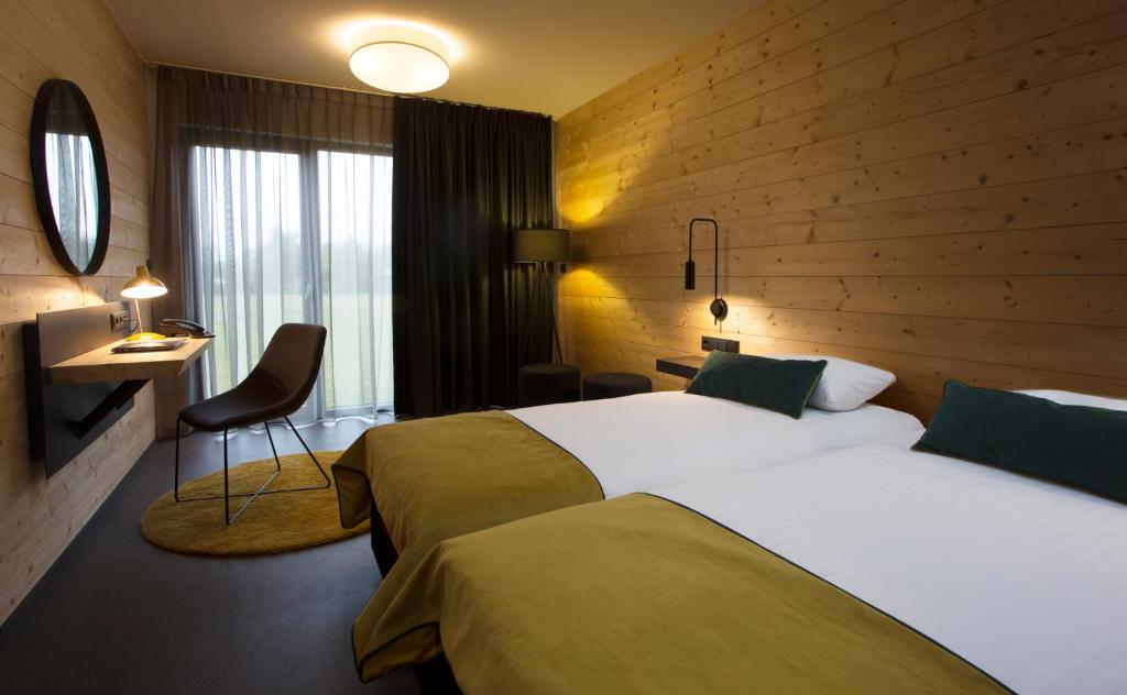 Przytulny pokój hotelowy z drewnianą ścianą i łóżkiem małżeńskim.