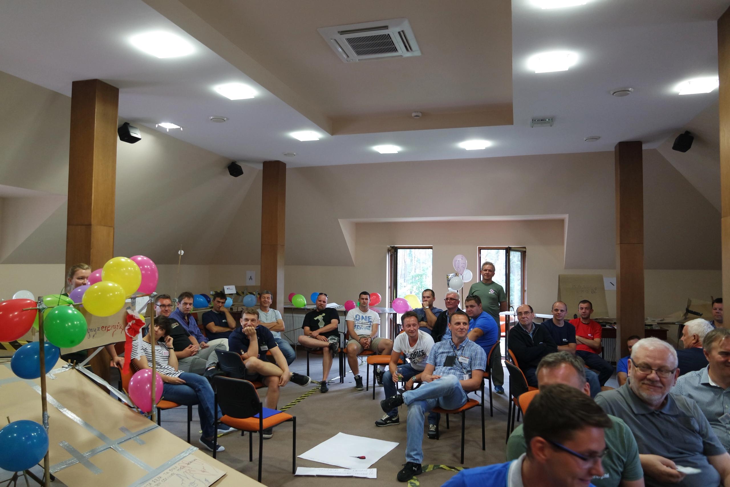 Grupa uczestników siedząca na sali konferencyjnej – briefing przed rozpoczęciem gry integracyjnej.